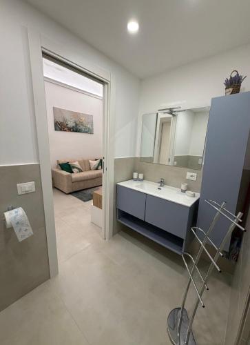 a bathroom with a sink and a mirror and a couch at Sorrento Gem House in Meta