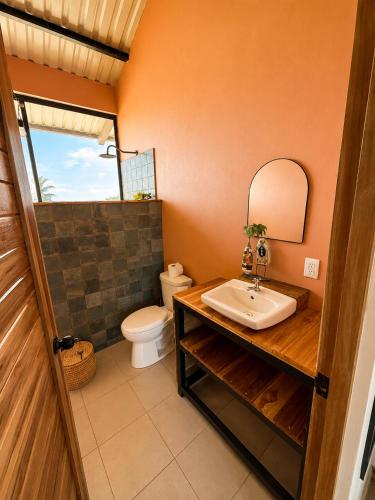 a bathroom with a sink and a toilet at Tipsy Gypsy Bar & Hotel in Tola