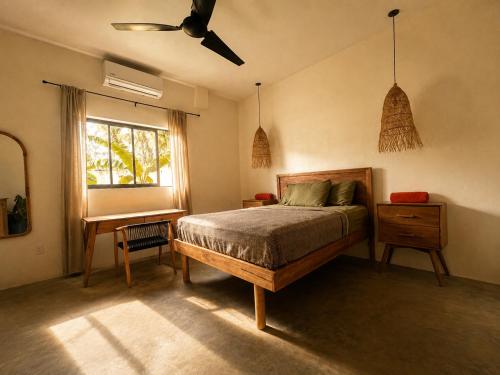a bedroom with a bed and a desk and a window at Tipsy Gypsy Bar & Hotel in Tola