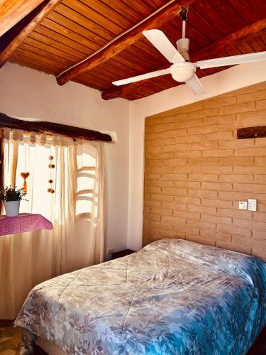 a bedroom with a ceiling fan and a bed at Las Pircas Apartamentos - Centro de Cafayate in Cafayate