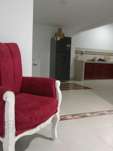 a red chair sitting in a living room at La Clandestina in Chachagüí