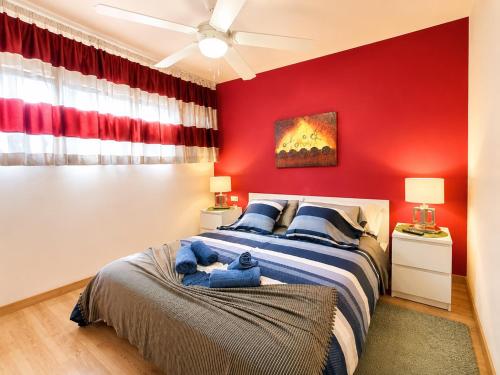 a bedroom with a bed with a red wall at Solymar Premium Apartment 2 in Playa del Ingles
