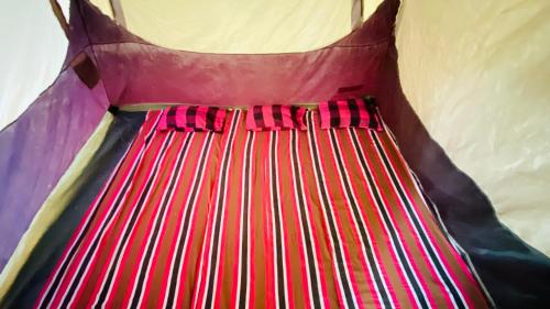 a red and black dress with a bow tie at Seravelle Adventure Camping in Kitulgala