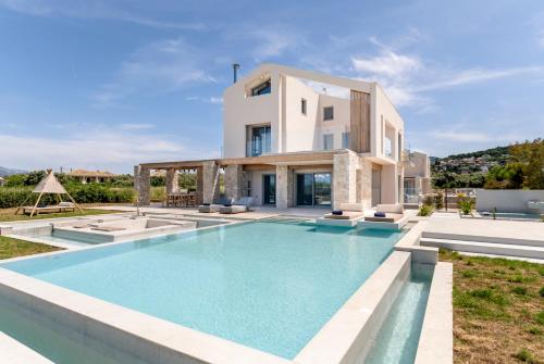 a villa with a swimming pool in front of a house at The Retreat Villa in Lefkada