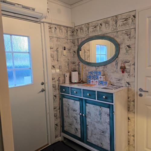 a bathroom with a blue cabinet and a mirror at Stuga Ani Wellness & Sauna in Svartå