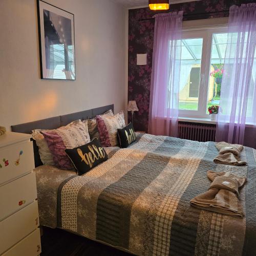 a bedroom with a bed with a blanket and a window at Stuga Ani Wellness & Sauna in Svartå