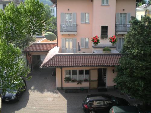 an apartment building with cars parked in front of it at Hotel La Locanda in Stresa