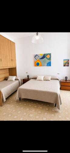 a bedroom with two beds and a painting on the wall at Casa Giulia in Pula