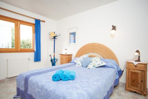 ソン・セッラ・デ・マリーナにあるVilla Germanorのベッドルーム1室(青いスリッパ付きのベッド1台付)