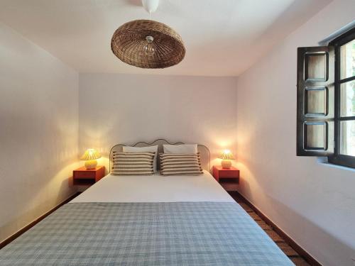 a bedroom with a bed with two lamps on both sides at Casa da Água Formosa in Vila de Rei