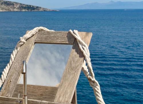 a wooden boat with a rope on the water at Albania Glamping in Himare