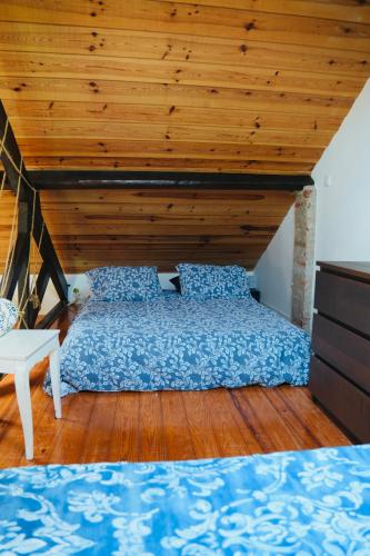 a bed in a room with a wooden ceiling at Loft beach in Vieira de Leiria