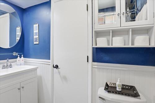 a bathroom with a white toilet and a blue wall at Private Dock, Boat Launch, Fire Pit & Lake Views in Sunrise Beach