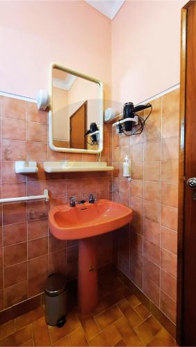 a bathroom with a red sink and a mirror at Casa dos Pomares in Figueira da Foz