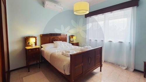 a bedroom with a large bed and a window at Casa dos Pomares in Figueira da Foz