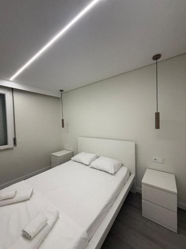 a bedroom with a large white bed and two tables at Casa Noir Luxury 3BR Apartment 2 Baths Near Lisbon & Sintra in Queluz