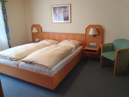 a bedroom with a large bed and a chair at Hotel Gasthaus zur Krone in Gochsheim