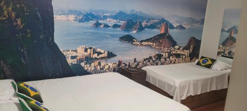 a room with two beds and a mural of a city at Hotel Alvorada do Sol in São Paulo