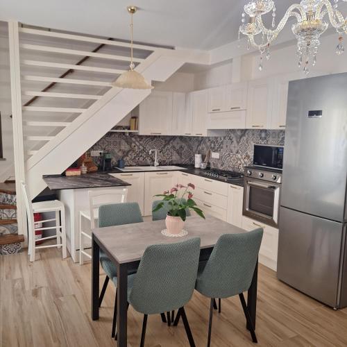 a kitchen with a table with chairs and a refrigerator at Casa Sant'Antonio Dimora Storica in Tarquinia