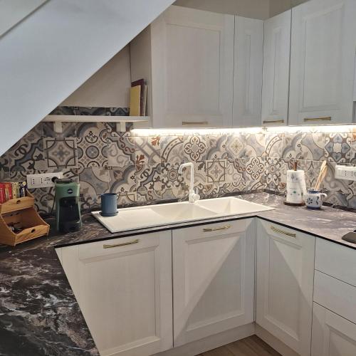 a kitchen with white cabinets and a sink at Casa Sant'Antonio Dimora Storica in Tarquinia