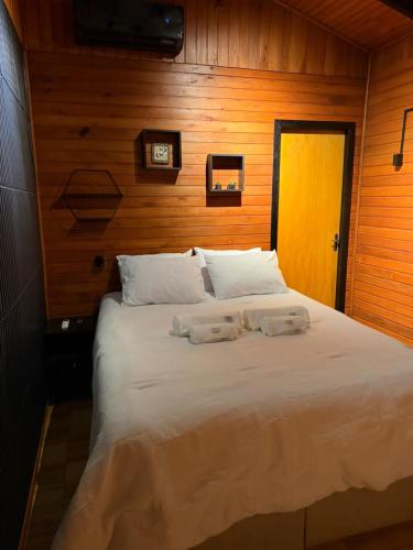 a bedroom with a bed with two towels on it at Cabana Refúgio da Montanha in Alfredo Wagner