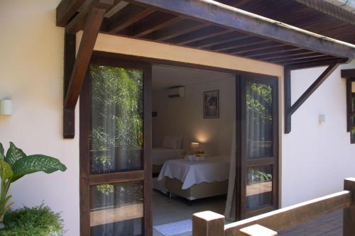a room with a door leading to a room with a table at Suites Amma Noronha in Fernando de Noronha