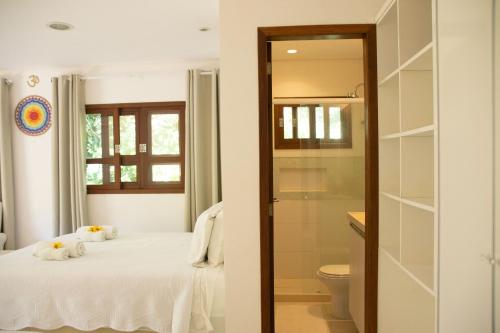 a bedroom with a bed and a shower and a toilet at Suites Amma Noronha in Fernando de Noronha