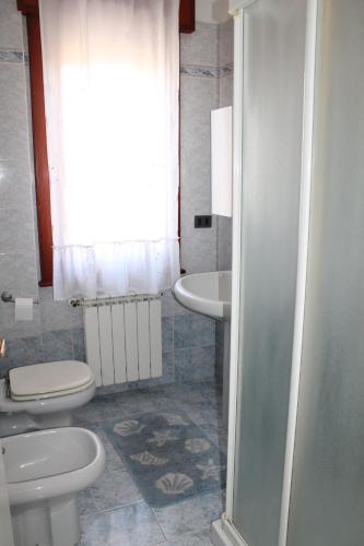 baño con 2 aseos y lavamanos en Condominio ai bagni en Grado