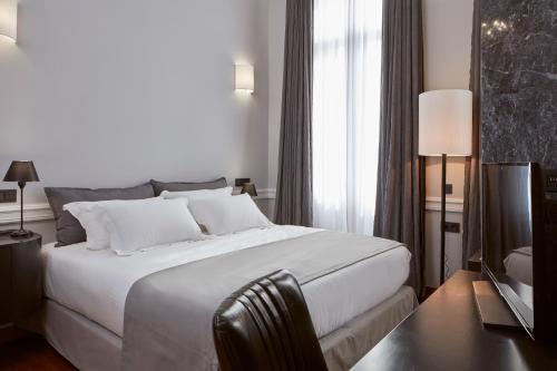 een slaapkamer met een groot wit bed en een raam bij The Zillers Boutique Hotel in Athene