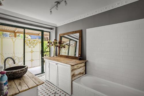 a bathroom with a tub and a sink and a mirror at Gorge Castle in forest landscape in Galston