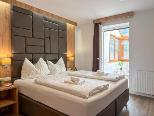 a bedroom with a large bed with two towels on it at Chalet-Apartment Alpenresidenz in Sankt Michael im Lungau