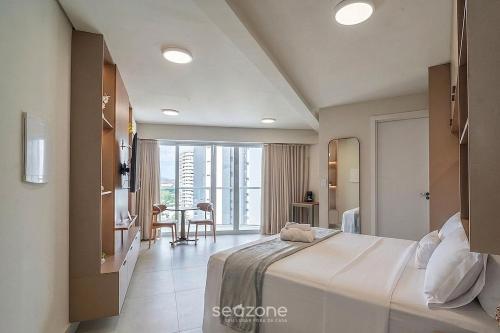 a hotel room with a large bed and a table at Studio in Condo with Pool and Gym MSU0906 in Governador Valadares