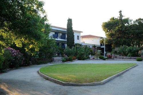 a garden with a lawn in front of a building at Delfinia Hotel & Bungalows in Mithymna