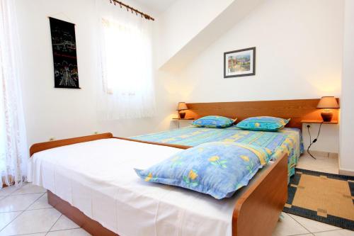 a bedroom with a bed with blue pillows at Apartments by the sea Sevid, Trogir - 9468 in Sevid