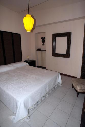 a bedroom with a white bed and a yellow light at Sotto i merli in Vigevano