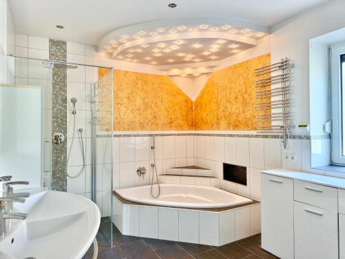a bathroom with a tub and a sink at Apartment Karawankenblick with Lake View - Free Parking in Pörtschach am Wörthersee