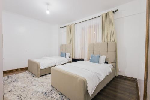 a bedroom with two beds and a window at Rolling in Nairobi