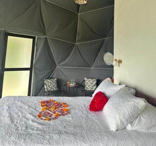 ein Schlafzimmer mit einem großen Bett mit grauem Kopfteil in der Unterkunft Morpho Glamping in Nuevo Arenal