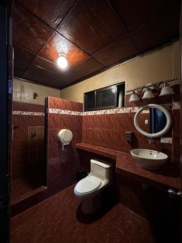 a bathroom with a toilet and a sink at Charly's Place in Alajuela