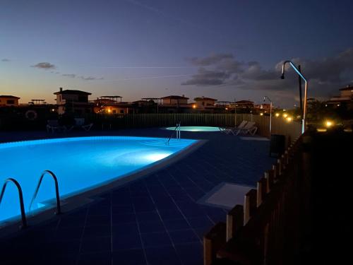 a large swimming pool at night with lights on at Mi Casa in Majanicho