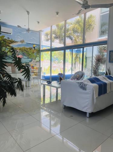 a living room with a white couch and a large window at Trade winds International in Progreso