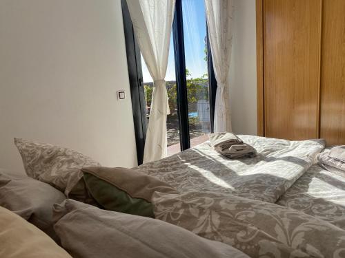 a bed sitting in a room with a window at Mi Casa in Majanicho