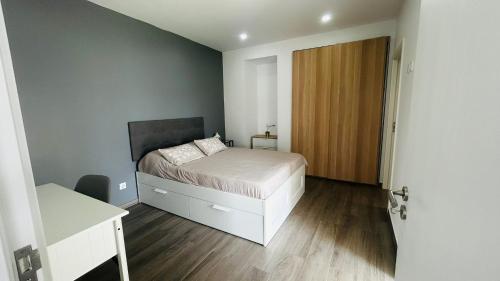 a small bedroom with a bed and a wooden door at Villa Pérola Pestana in Lourinhã