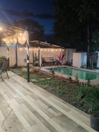a patio with a swimming pool at night at Cabañas Mantas in Tárcoles