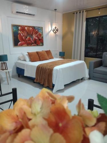 a bedroom with a bed and a room with a couch at Cabañas Mantas in Tárcoles