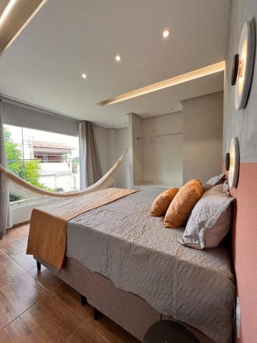 a bedroom with a large bed and a large window at Loft Moderno I in Mossoró