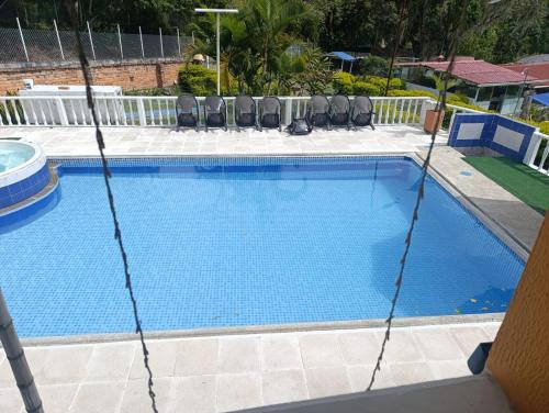 a large blue swimming pool with chairs around it at Cabañas Creation Garden - Espacio de Vida Saludable in San Francisco