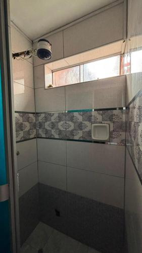 a bathroom with a window and a tiled wall at VillaHouse - Huaraz in Huaraz