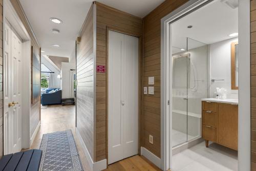 a bathroom with a walk in shower and a sink at Powder's Edge by Whiski Jack in Whistler