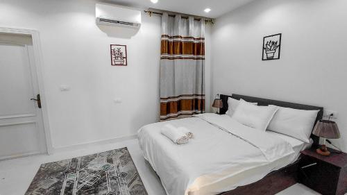 a bedroom with a bed with white sheets and a window at 325 · 2BR Townhouse 2 Bath TV in Sheikh Zayed